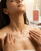 Woman applying a Coffy Salve  Body lotion product to her shoulder with a bottle of cream in the background.