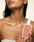 Person holding a bottle of  Coffy Salve  Body lotion  against a neutral background