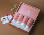 Set of skincare products in a pink box with 'SANATLYN' branding on a brown background.