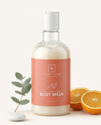 Bottle of Sanatlyn Hydrating & Brightening Body Wash with oranges and eucalyptus on a white background
